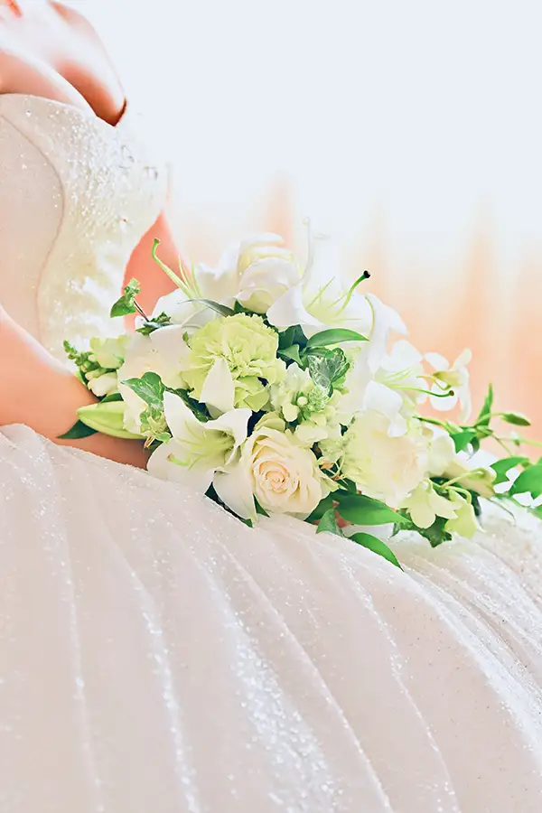 椅子に座るウェディングの新婦と白いブーケ